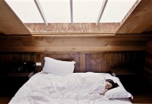 Apnée du sommeil : les 4 traitements Femme qui dort sous une fenêtre avec l'apnée du sommeil.