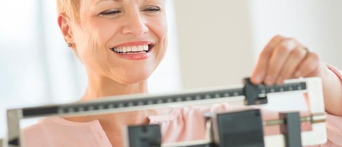 La sleeve endoscopique expliquée en 4 points Femme après une sleeve endoscopique qui se pèse.